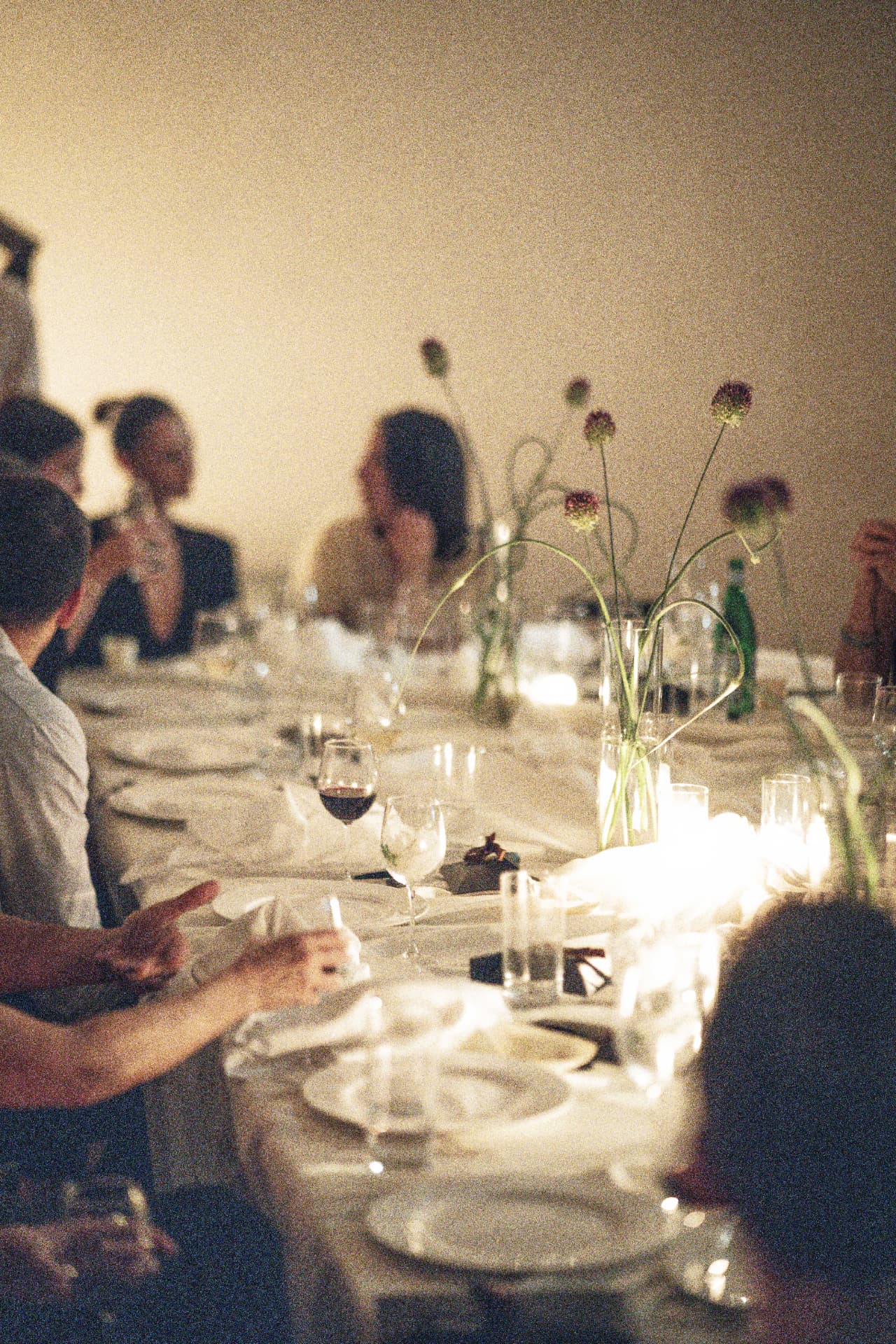 A long candlelit table mid-conversation at a Cureators evening