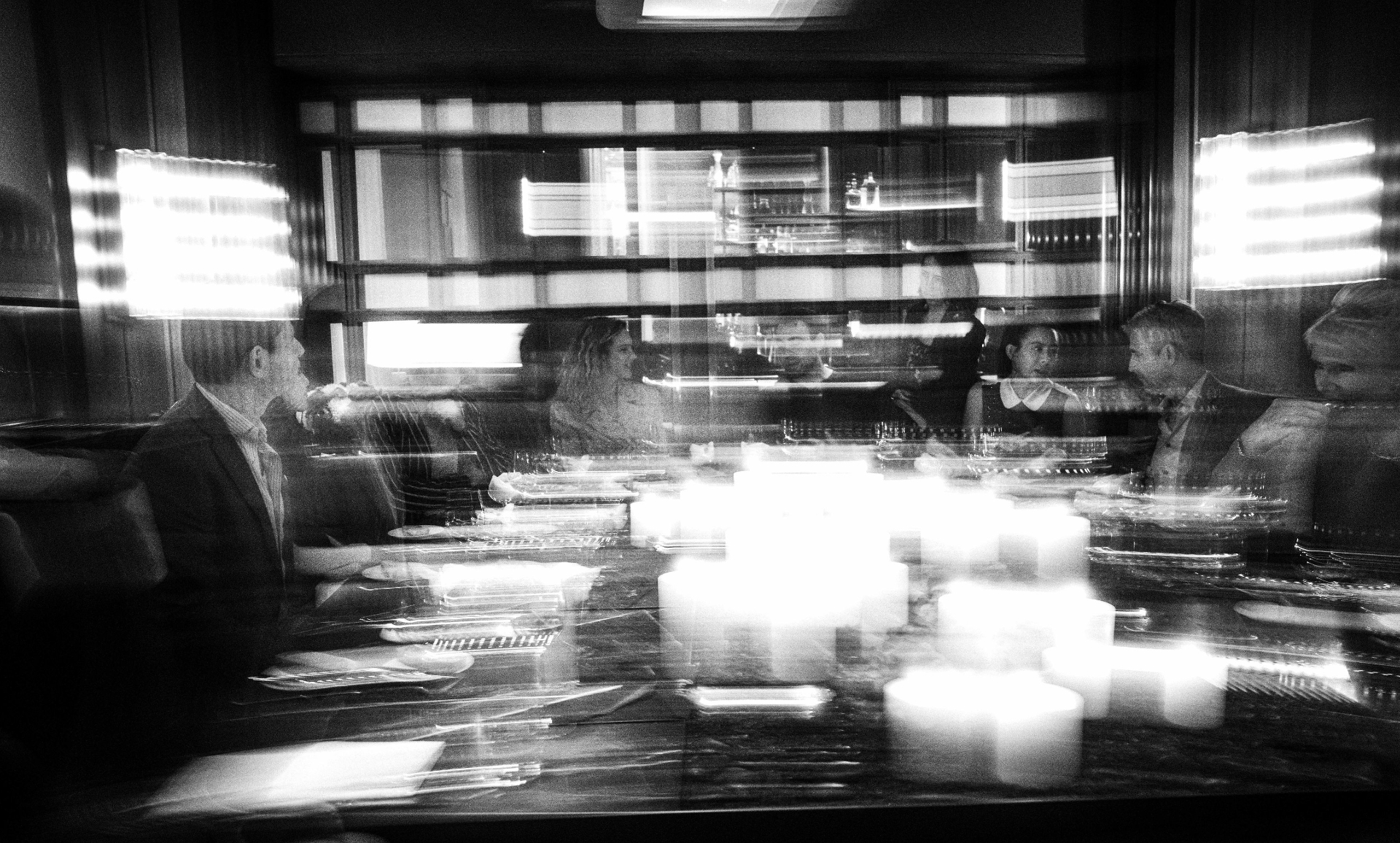 A long-exposure photograph of a candlelit dinner in motion