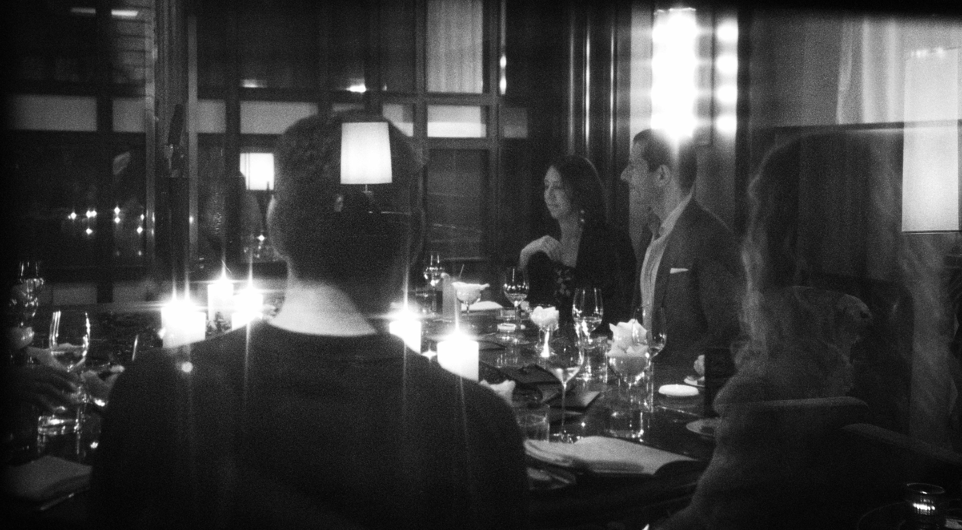 An intimate black-and-white photograph from a dinner gathering